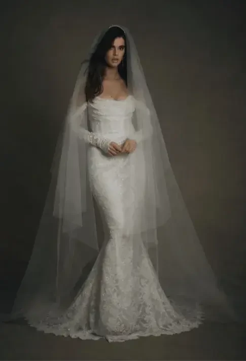 Model is wearing a beaded lace long sleeve wedding dress