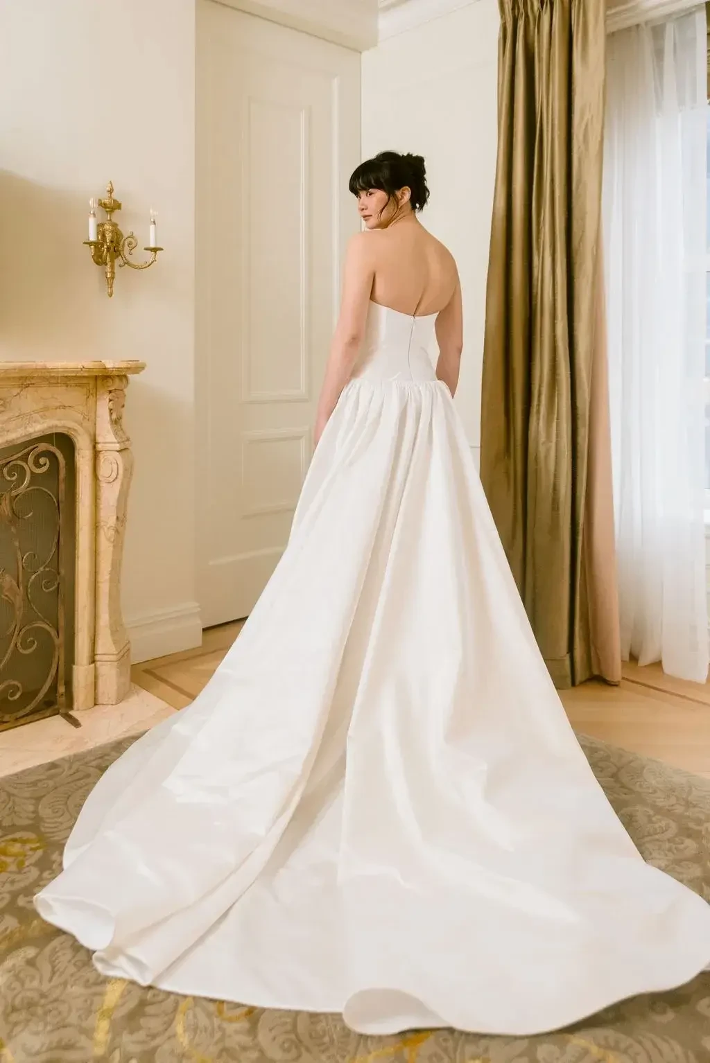 model is wearing a strapless ball gown with a structured bodice