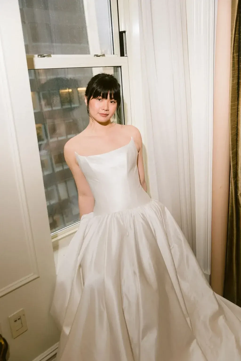 model is wearing a strapless ball gown with a structured bodice