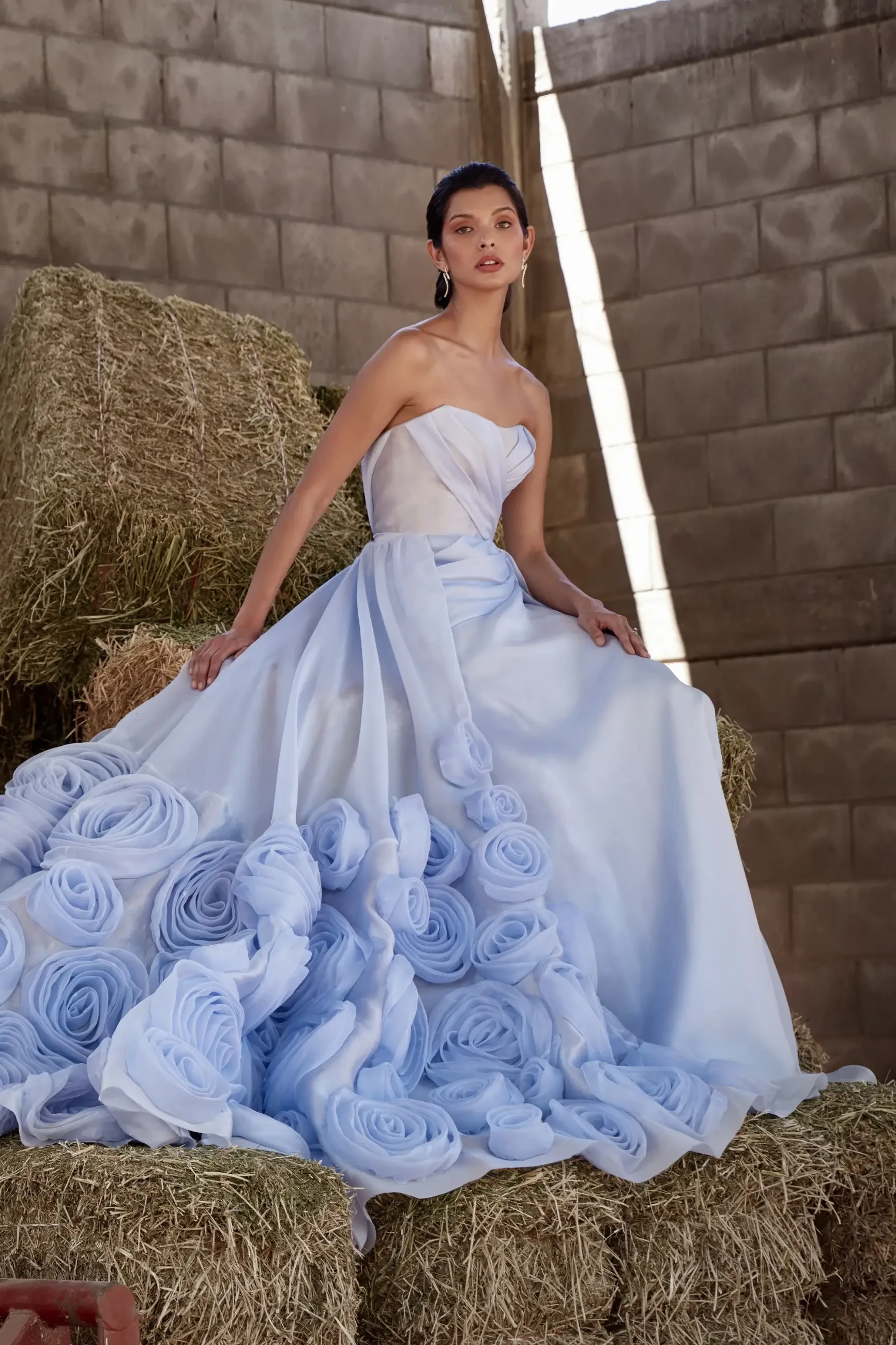 model is wearing a light blue strapless bridal gown with a detachable overskirt for texture