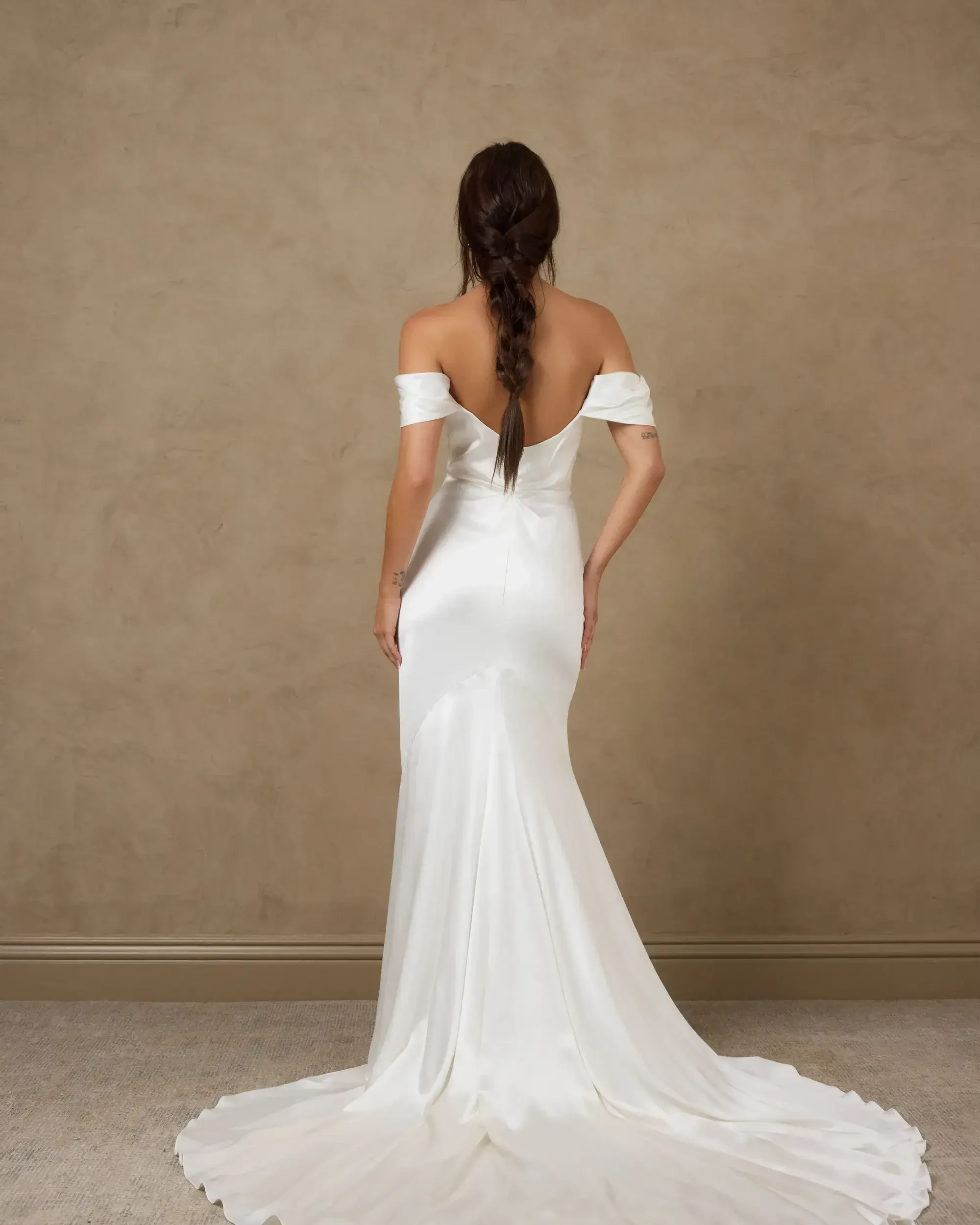 model is wearing an off the shoulder fit and flare bridal gown