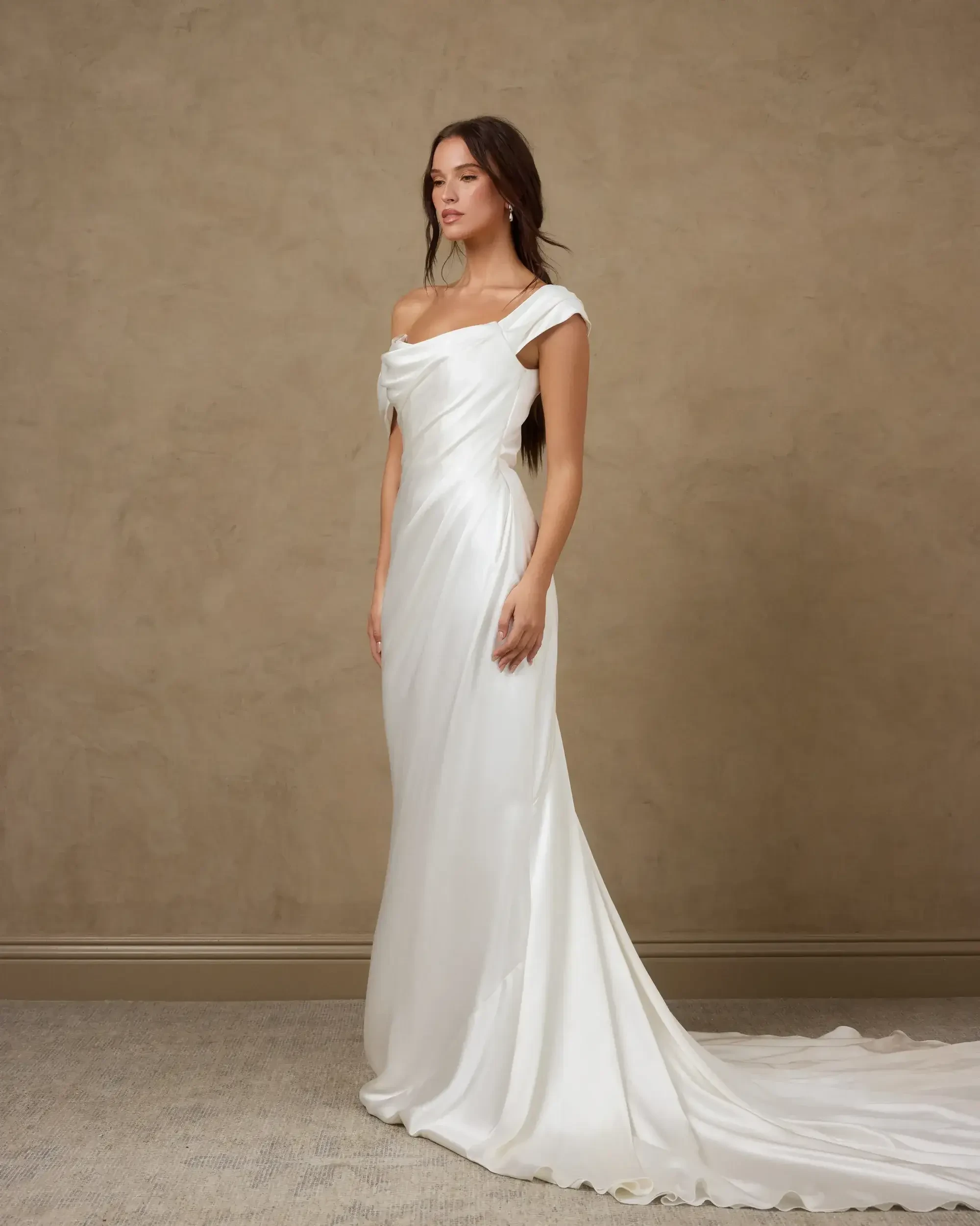 model is wearing an off the shoulder fit and flare bridal gown
