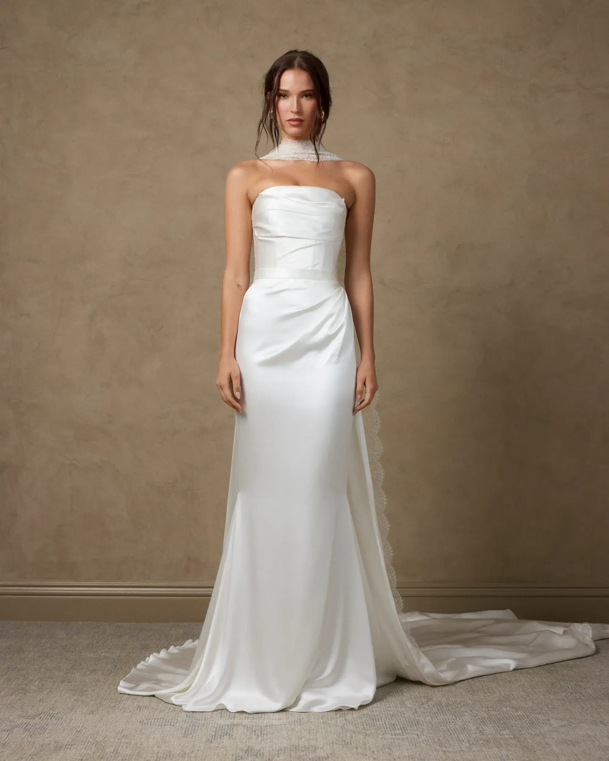 model is wearing a strapless sheath wedding dress