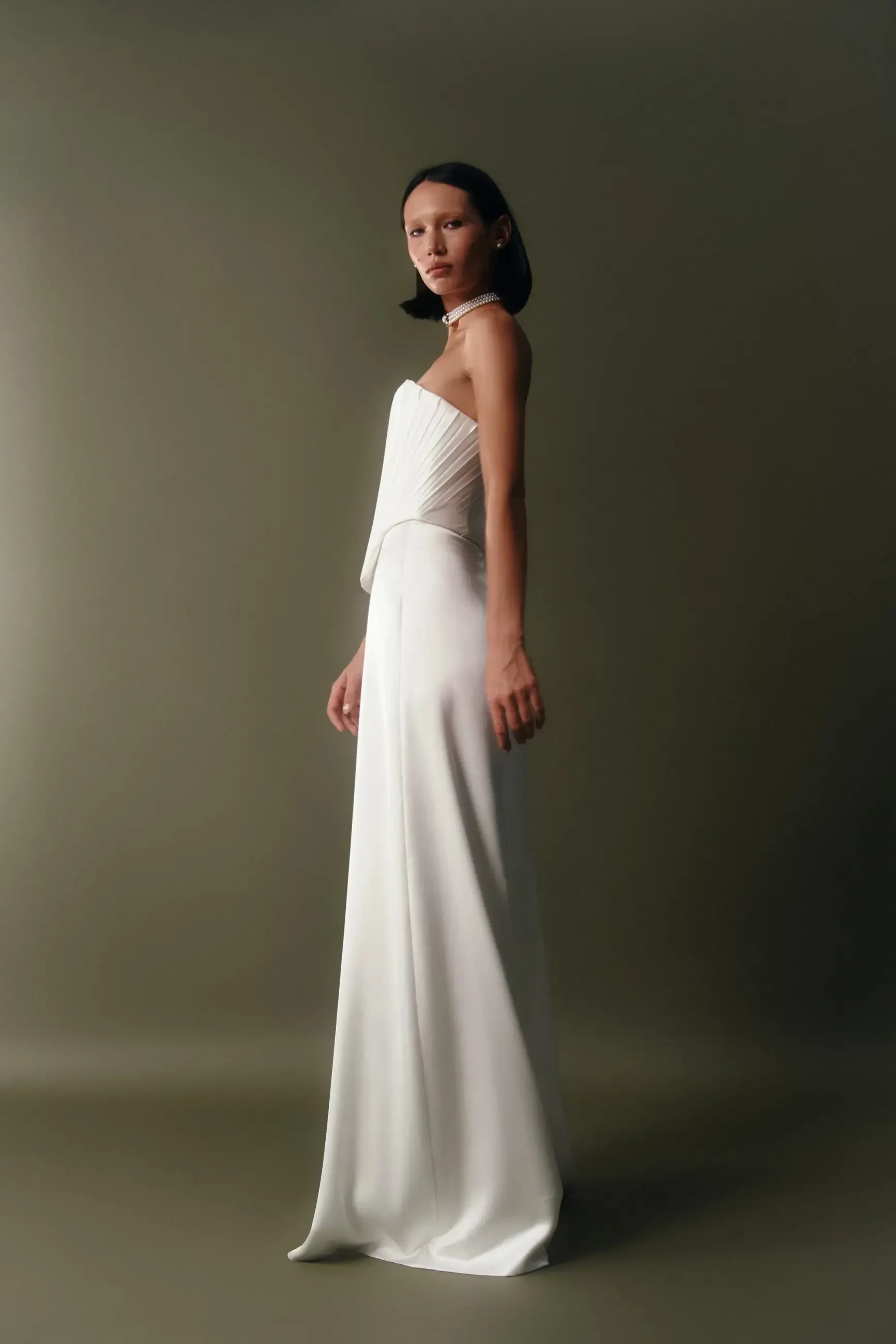 model is wearing a strapless sheath wedding dress with a structured corset bodice