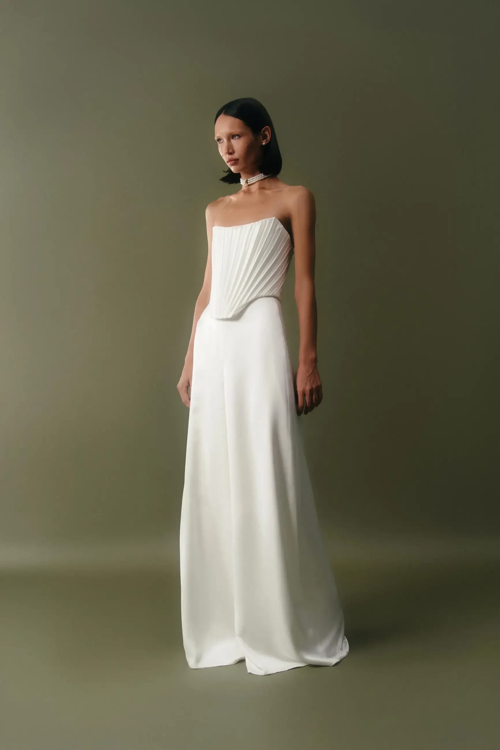 model is wearing a strapless sheath wedding dress with a structured corset bodice