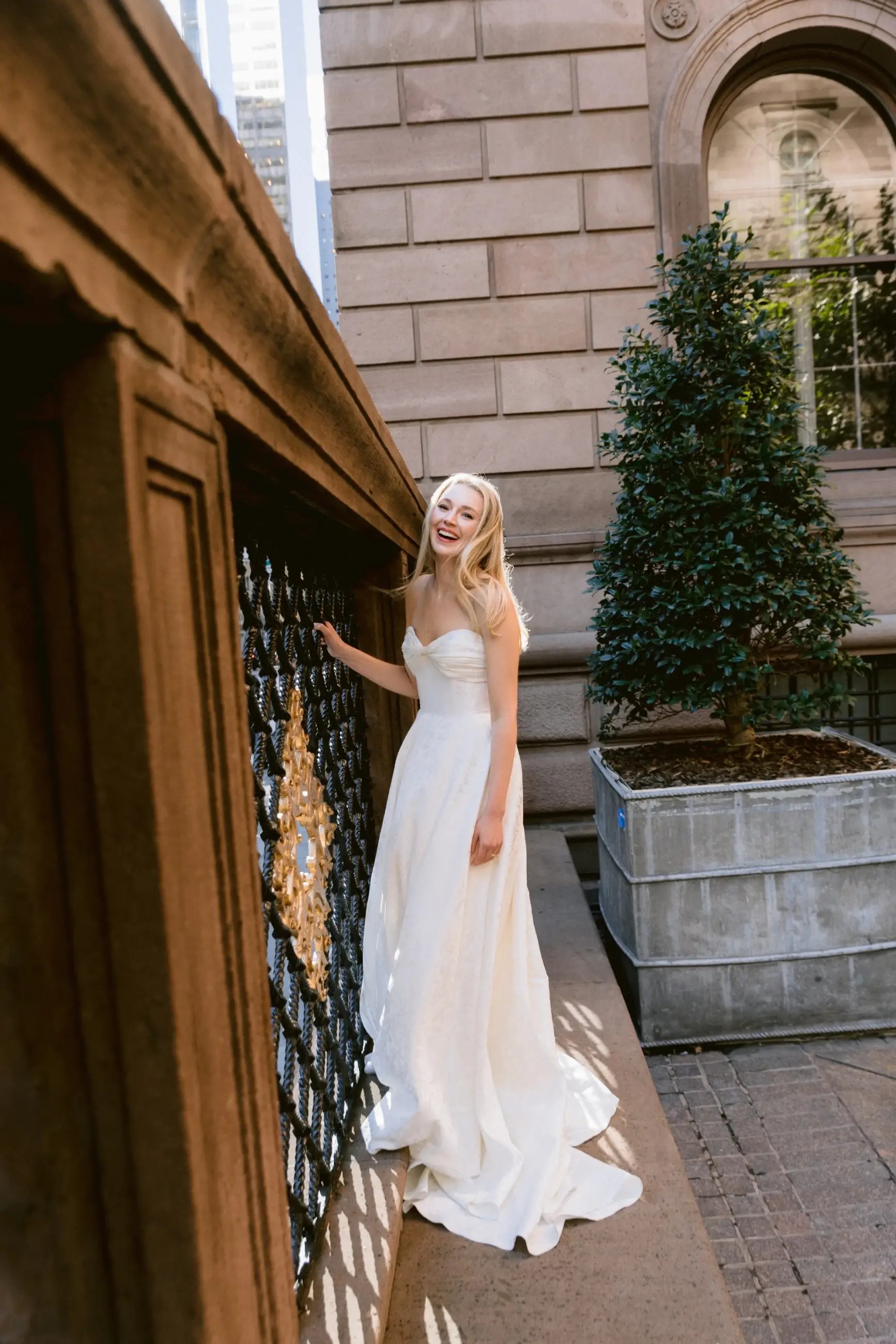 Model is wearing a strapless a-line wedding dress with ruching on the sweetheart bodice