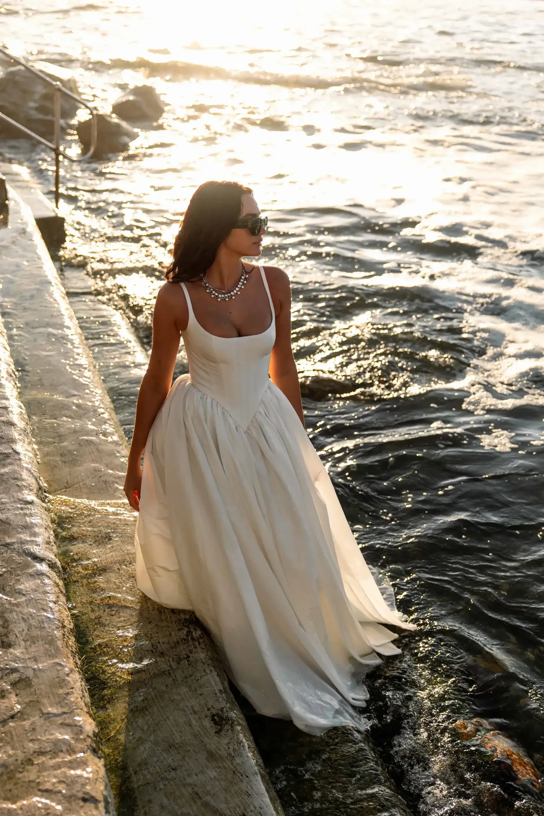 model is wearing a sleeveless scoop neck wedding gown