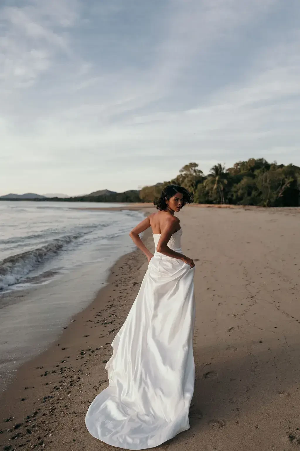 model is wearing a strapless sheath wedding dress